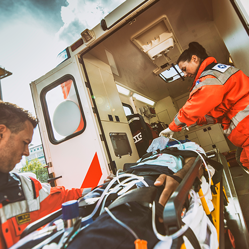 professionals loading patient into ambulance